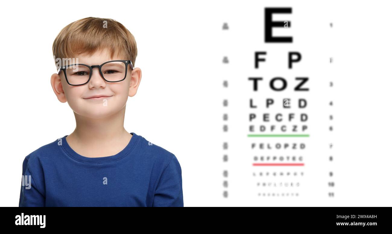 Test di visione. Simpatico bambino con occhiali e eye chart su sfondo bianco, design banner Foto Stock