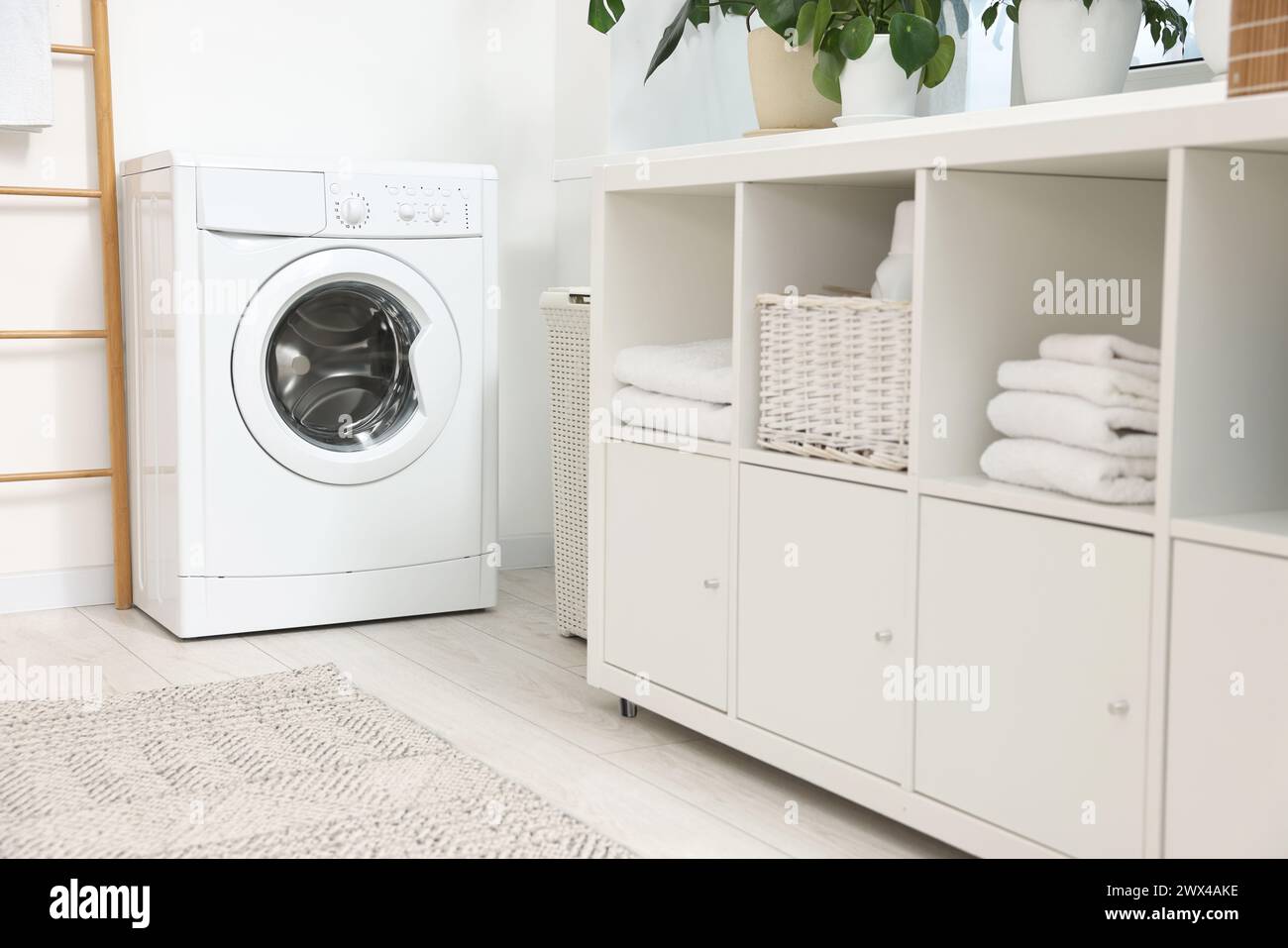 Interno della lavanderia con lavatrice e mobili Foto Stock