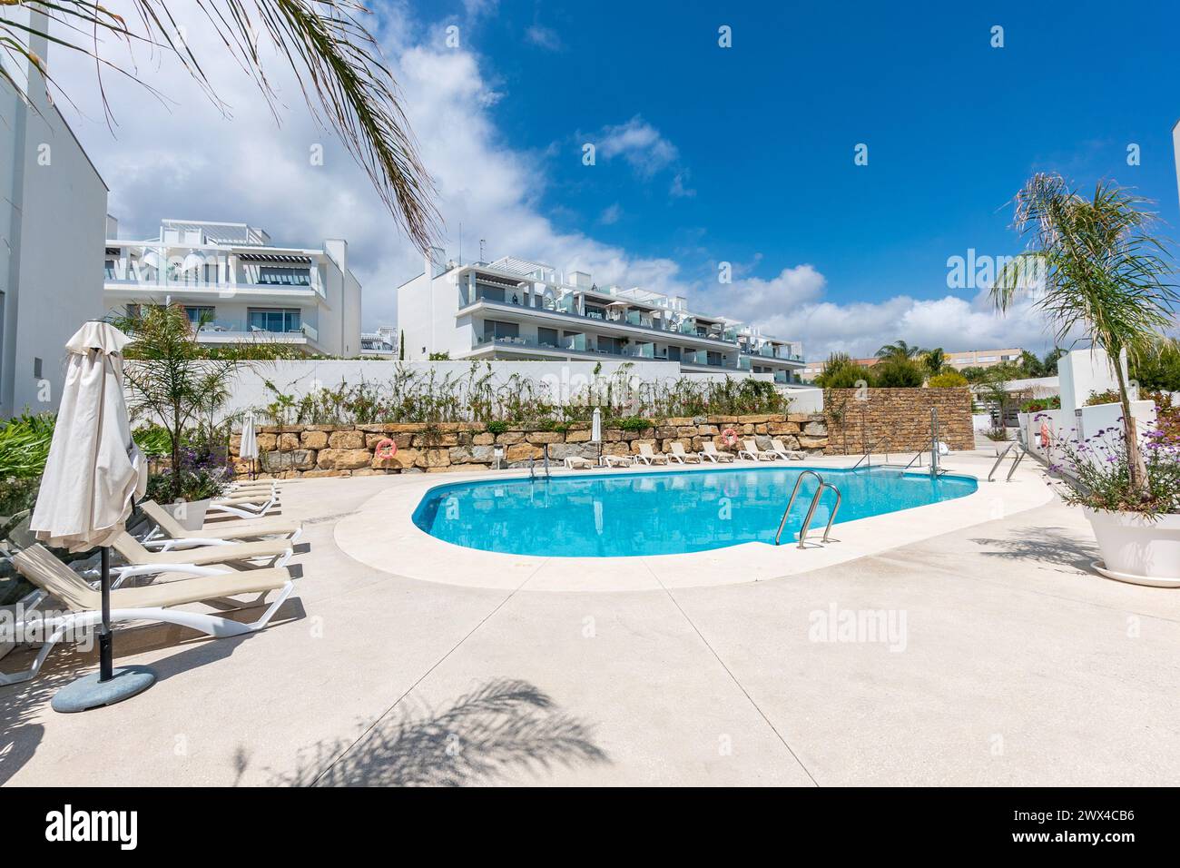un'immagine a bordo piscina accanto ad una lussuosa piscina comunitaria nel resort mediterraneo Foto Stock