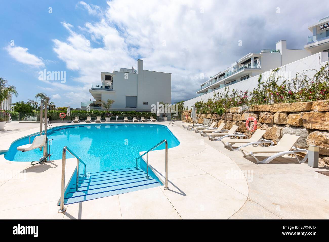 un'immagine a bordo piscina nella lussuosa piscina comunitaria del complesso residenziale mediterraneo Foto Stock