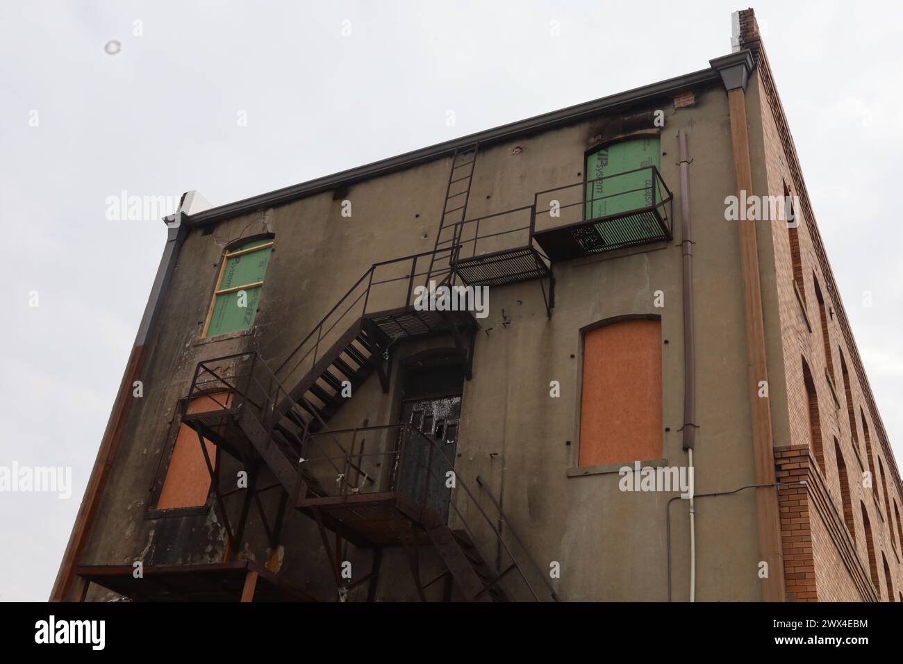 Una scala appoggiata contro un edificio con finestre a bordo Foto Stock