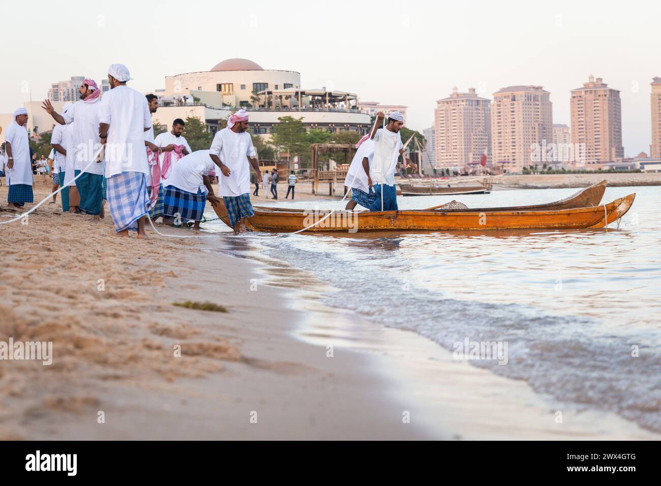 I pescatori arabi su un'antica barca di legno vanno a pescare al tramonto. Conservazione delle tradizioni nazionali, dell'artigianato antico, dello stile di vita storico Foto Stock