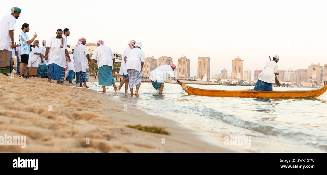 I pescatori arabi su un'antica barca di legno vanno a pescare al tramonto. Conservazione delle tradizioni nazionali, dell'artigianato antico, dello stile di vita storico Foto Stock