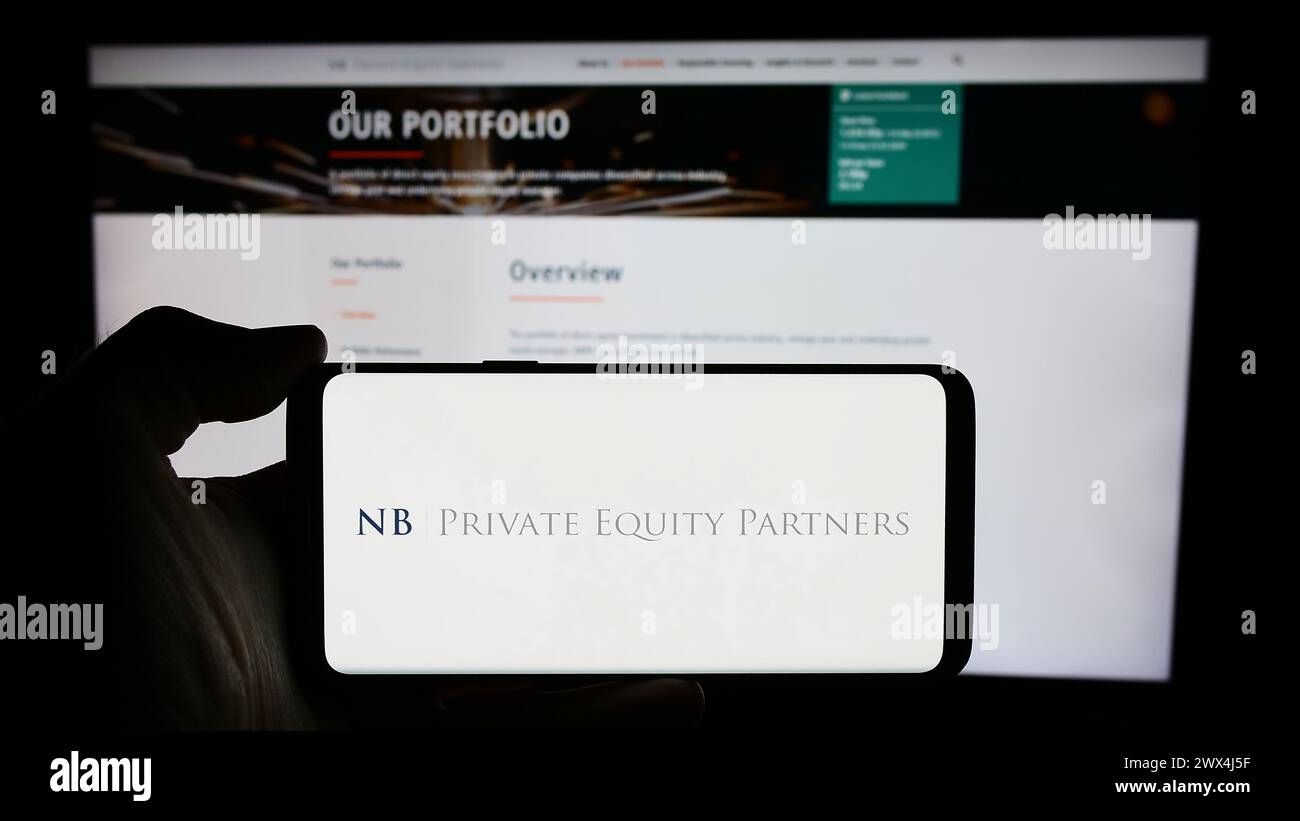Persona che detiene il cellulare con il logo della società britannica NB Private Equity Partners Ltd. (NBPE) davanti alla pagina Web. Mettere a fuoco il display del telefono. Foto Stock