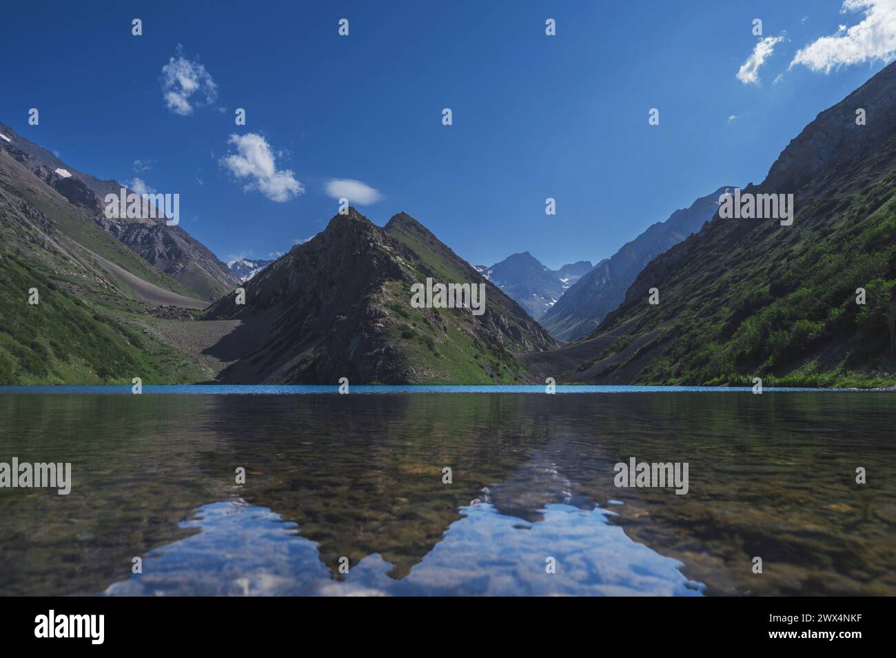 Lago con acqua cristallina nelle montagne sotto il cielo con nuvole in estate Foto Stock