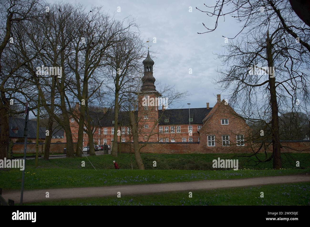 Husum, Schleswig-Holstein Blick von Schlossgarten auf das Schloss vor Husum so genannt, weil es zu seiner Erbauungszeit vor der Stadtgrenze lag. Es War ursprünglich eine Nebenresidenz des herzoglichen Hauses Schleswig-Holstein-Gottorf und diente im 18. und 19. Jahrhundert als gelegentliche Residenz des dänischen Königshauses. Bereits während dieser Zeit nahm das nun Königliche Schloss die Amtsverwaltung auf, die sich nach 1864 fast auf das ganze Haus ausdehnte und hier bis ins 20. Jahrhundert verblieb. Aufnahme vom 27.03.2024, Husum, Kreis Nordfriesland, Schleswig-Holstein *** Husum, Schleswig Foto Stock