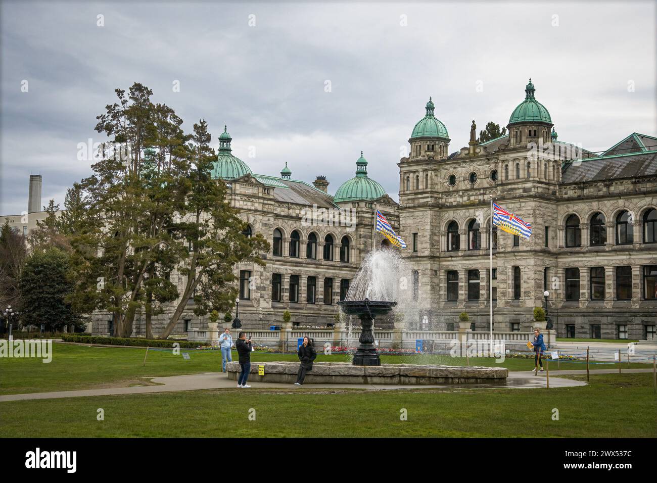 Di fronte all'edificio governativo del Parlamento con fontana in una giornata d'inverno ventilata e bandiere aperte. Foto Stock