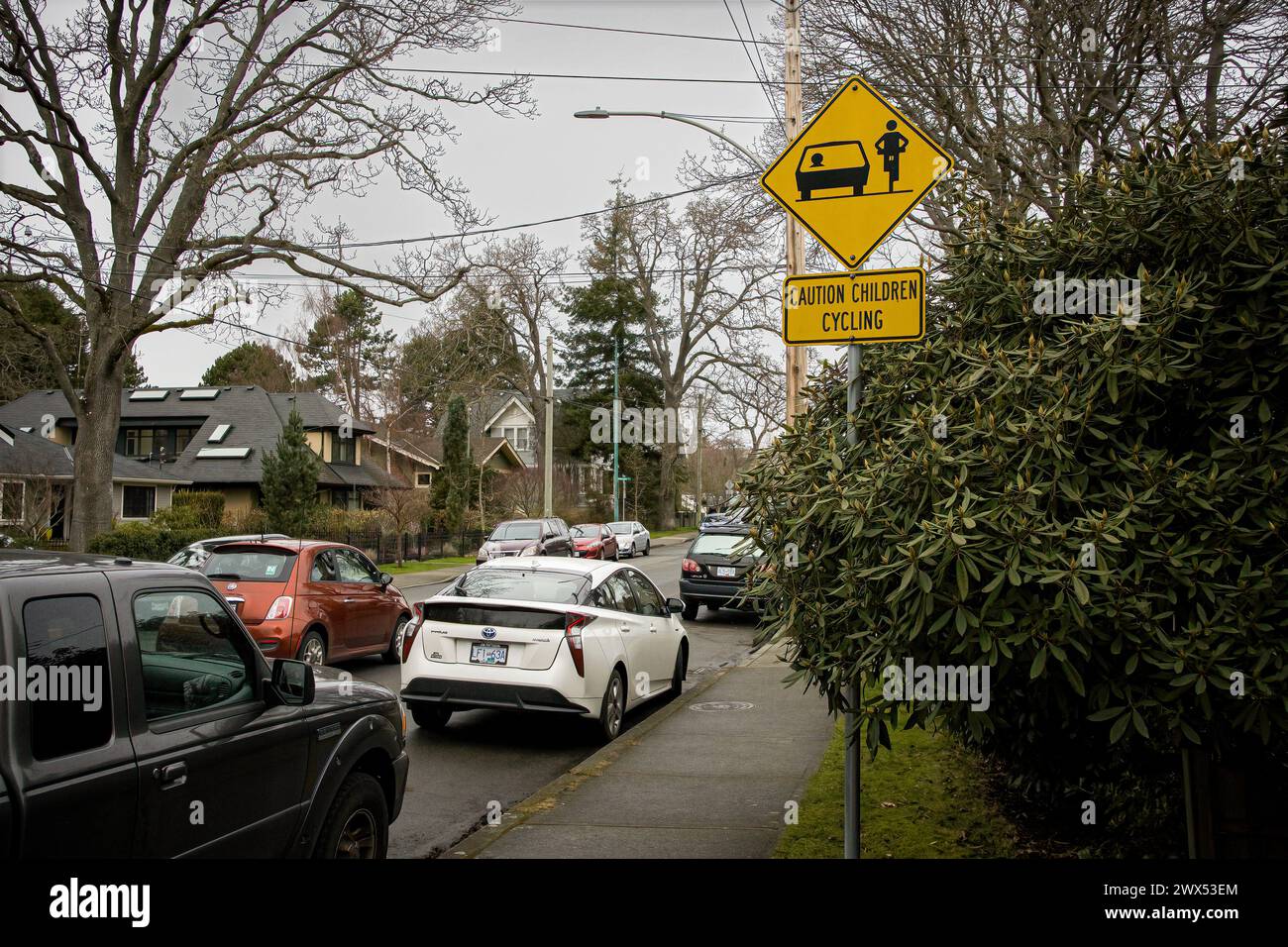 Foto di un cartello di avvertimento giallo sui bambini in bicicletta nel quartiere di Oak Bay, nella capitale della provincia. Foto Stock