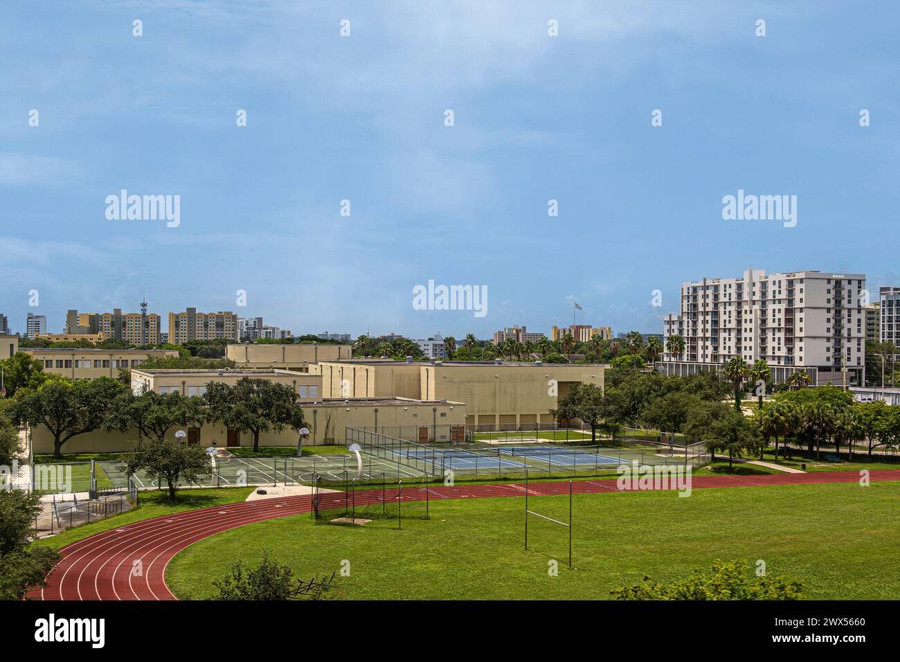 Miami, Florida, USA - 29 luglio 2023: Booker T. Washington Senior High School campi sportivi ed edifici sotto il cielo blu. St Appartamenti del Martins Place Foto Stock