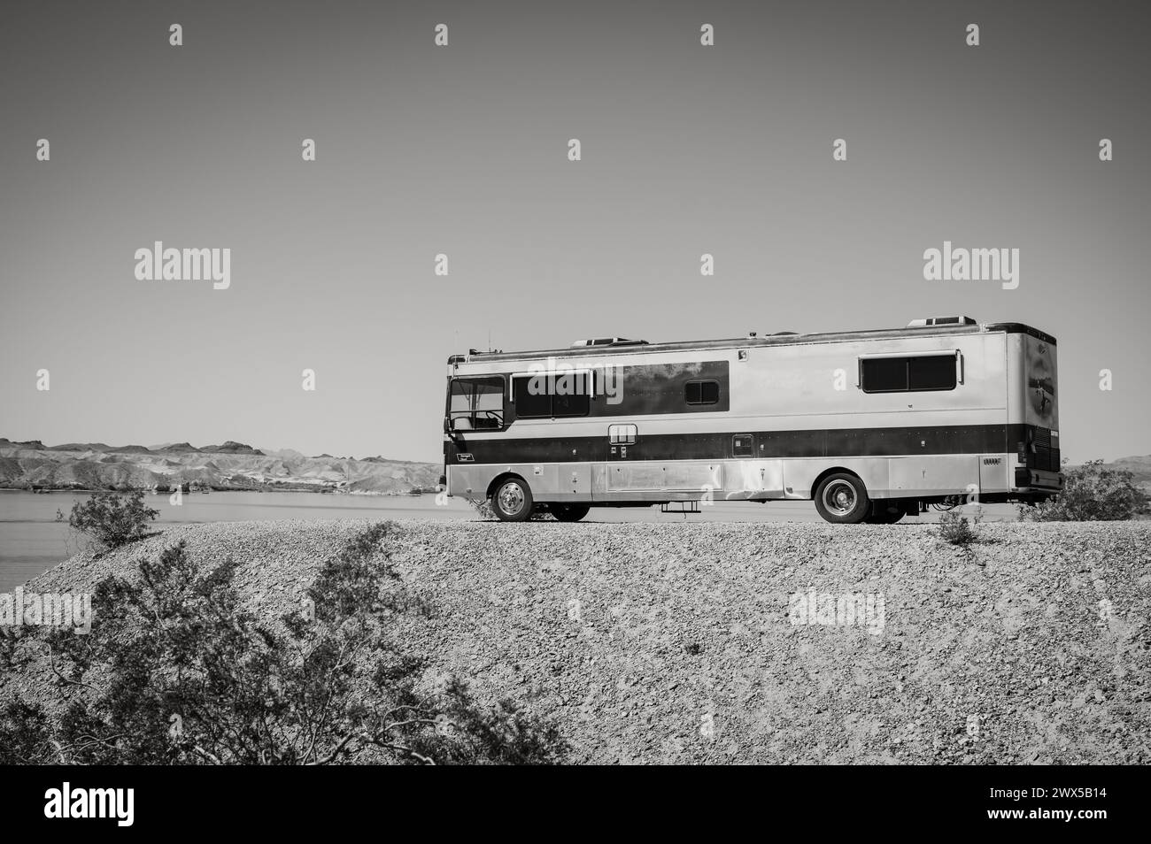 Un grande camper in stile autobus parcheggiato sulle rive del Lago Havasu. Lake Havasu City, Stati Uniti. Immagine in bianco e nero. Foto Stock