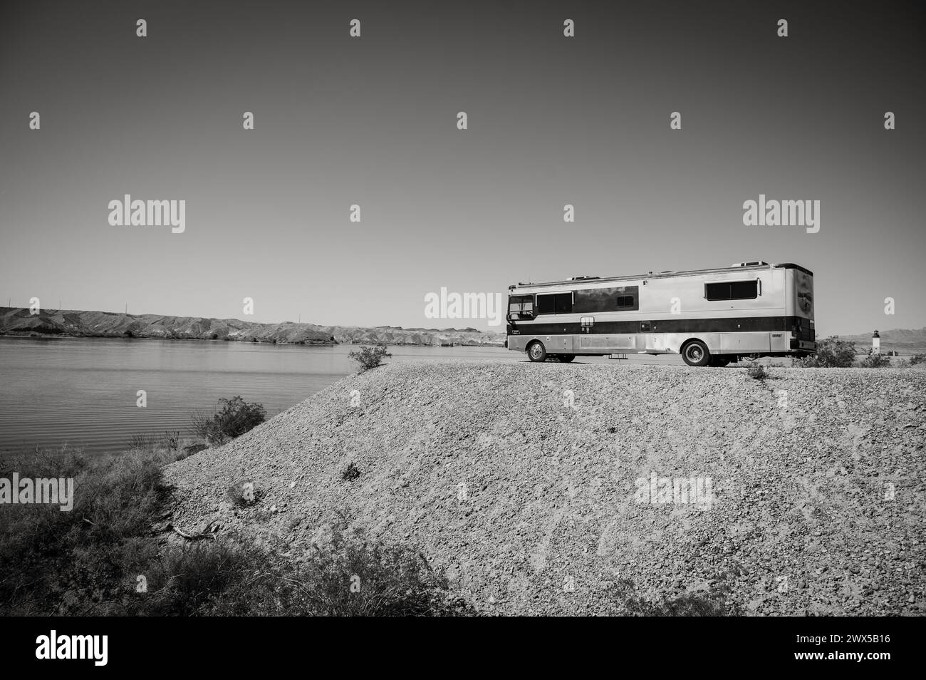 Un grande camper in stile autobus parcheggiato sulle rive del Lago Havasu. Lake Havasu City, Stati Uniti. Immagine in bianco e nero. Foto Stock