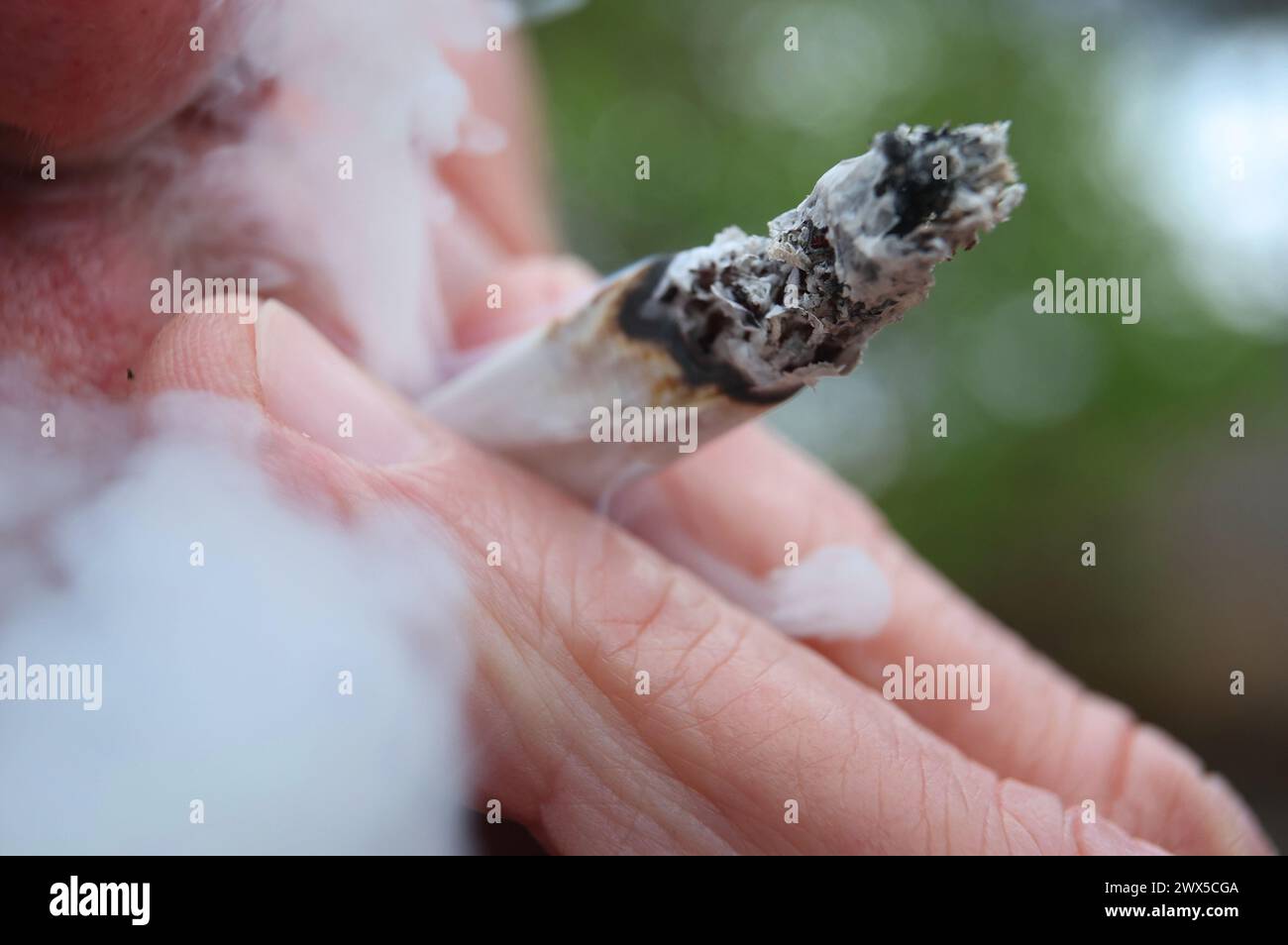 Augusta, Germania. 21 marzo 2024. Un uomo fuma uno spinello. Il 22 marzo, il Consiglio federale ha aperto la strada alla parziale legalizzazione della cannabis il 1° aprile. Crediti: Karl-Josef Hildenbrand/dpa/Alamy Live News Foto Stock