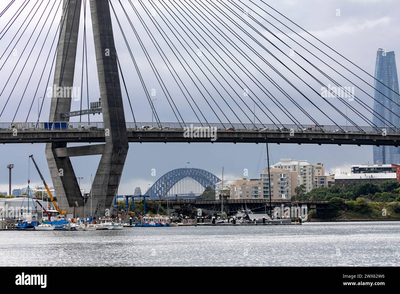 Ponte Anzac visto dal parco della baia di Blackwattle, con il Sydney Harbour Bridge in lontananza e il Crown Casino Barangaroo, pilone e ponte di campata, New South Wales, Australia Foto Stock