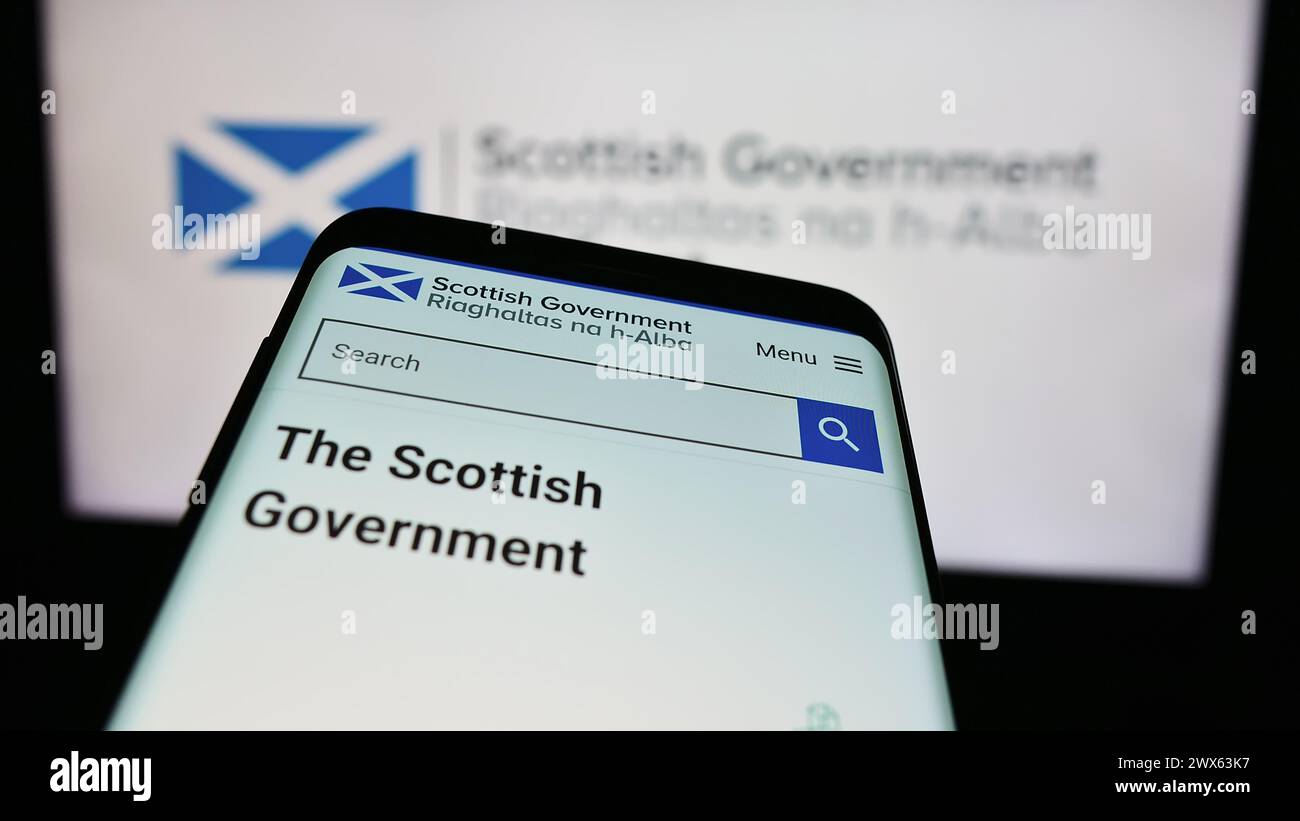 Telefono cellulare con sito web del governo scozzese (Riaghaltas na h-Alba) davanti al logo. Mettere a fuoco in alto a sinistra sul display del telefono. Foto Stock