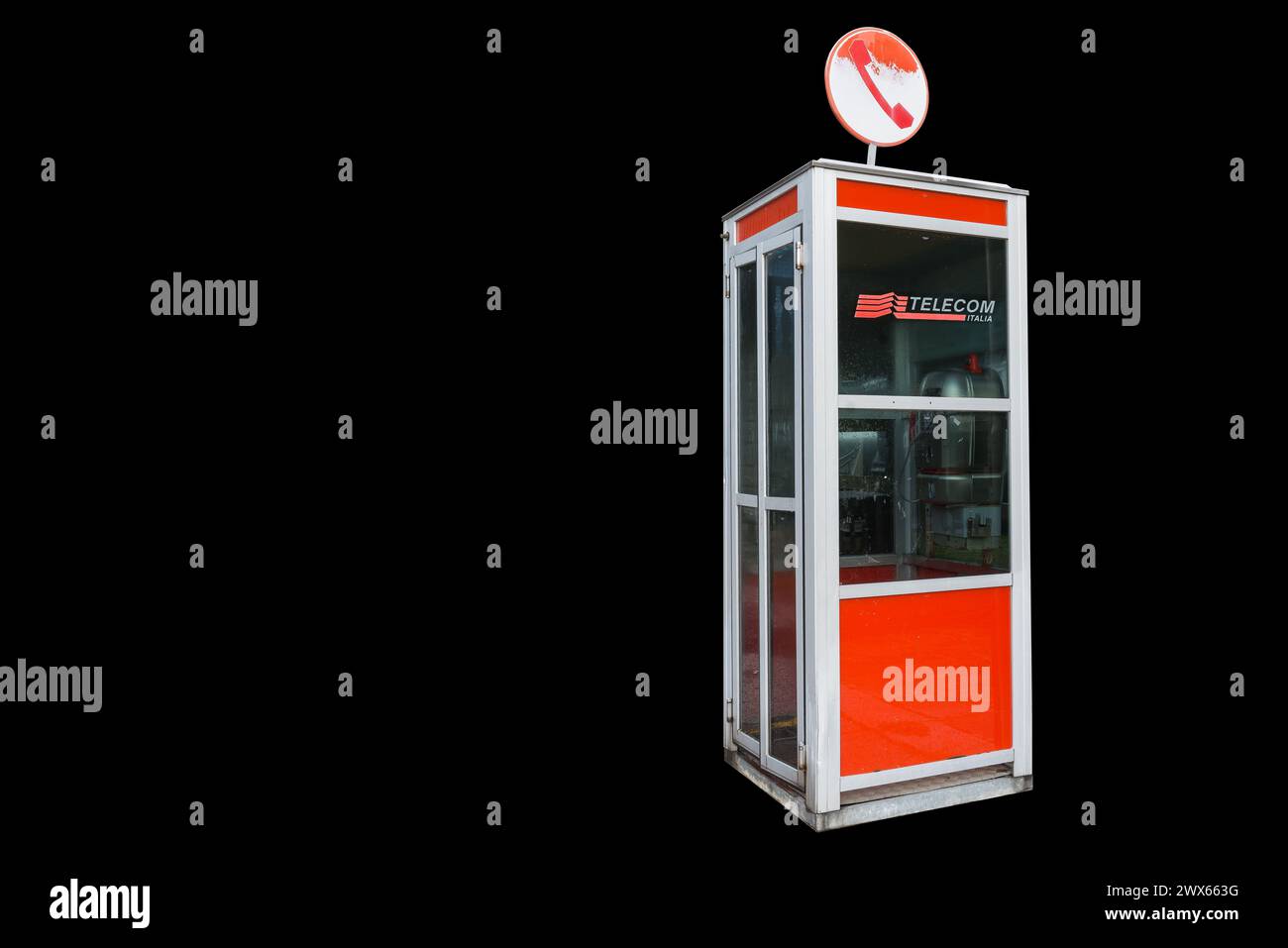 Cabina telefonica di Telecom Italia. Concetto di tecnologia e oggetto obsoleto isolato su sfondo nero. TIM Spa (precedentemente Telecom Italia Spa) Foto Stock