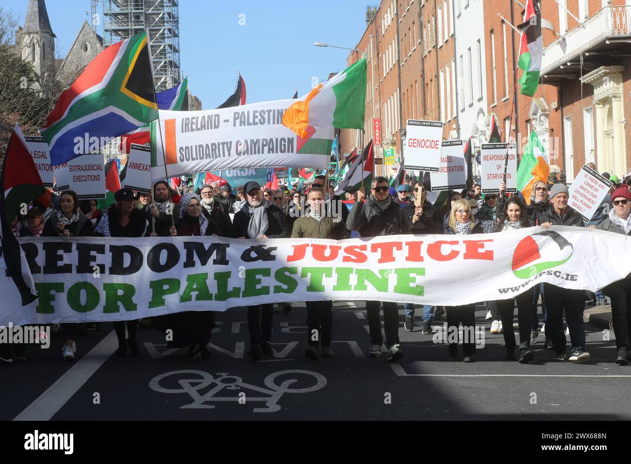 I manifestanti marciano dietro uno striscione che dice libertà e giustizia per la Palestina in una marcia anti-Israele a Dublino. Foto Stock