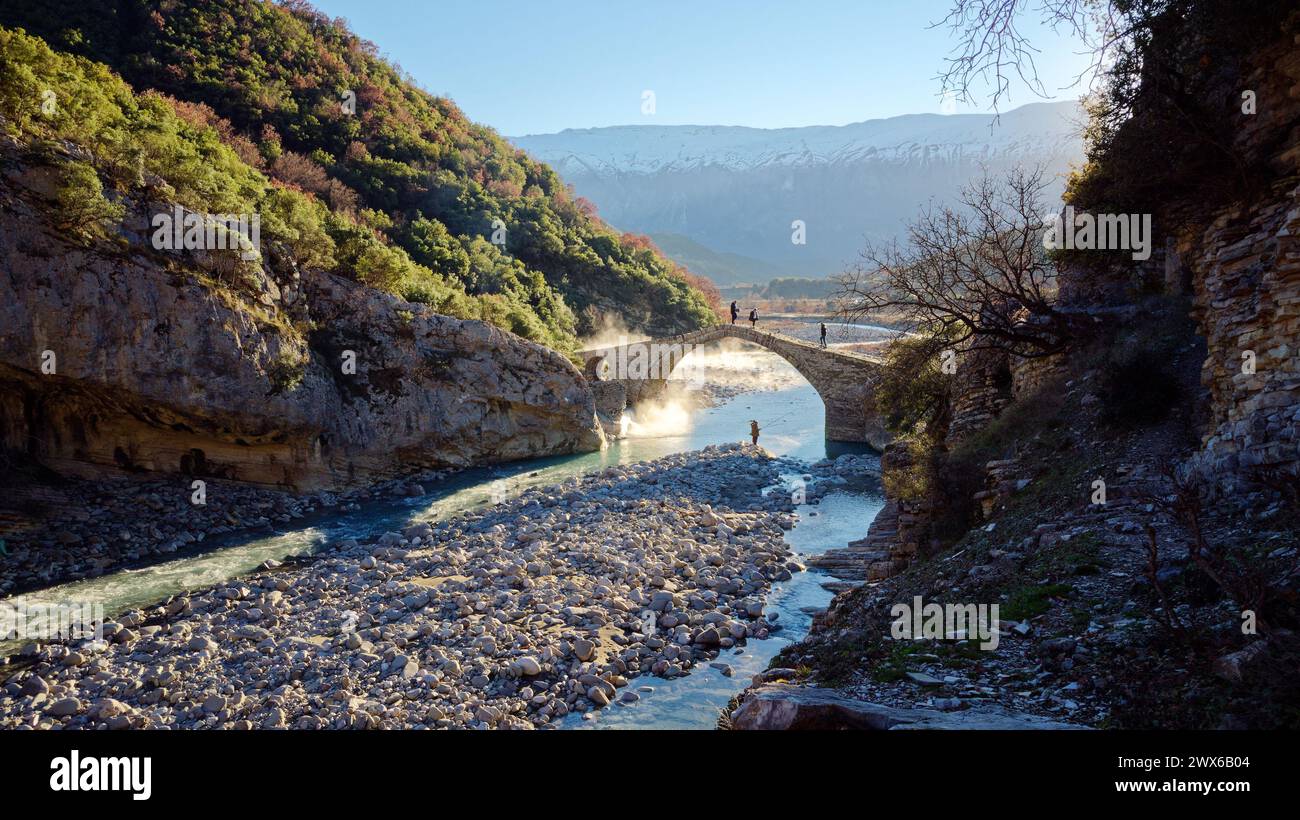 Persone che attraversano il ponte di Kadiut a Benje, Permet, Albania. Antico ponte di pietra. Bellissime meraviglie naturali. Vacanze e tempo libero. Foto Stock