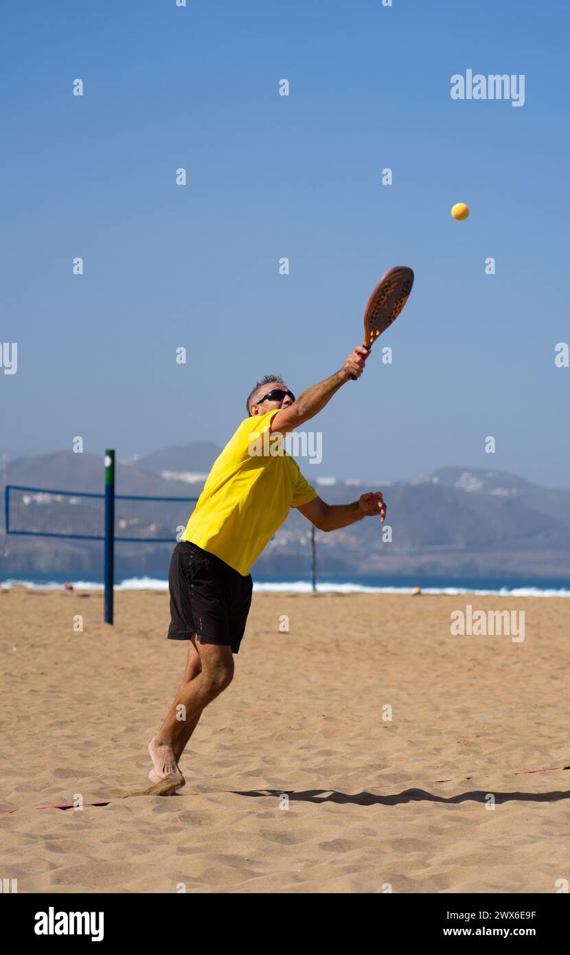 Uomo anziano che gioca a Beach tennis Foto Stock