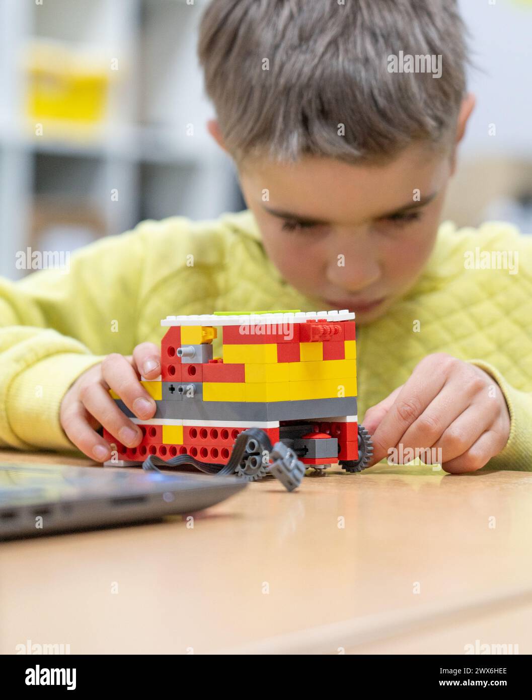 Bambino concentrato in un'officina robotica Foto Stock