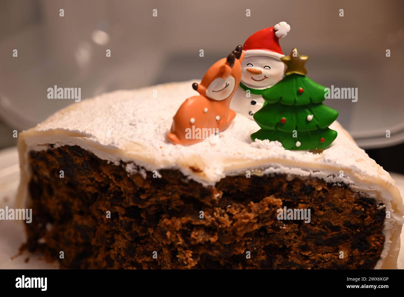 Fetta di ricca torta di frutta ghiacciata, torta di Natale, con i copritorta. Foto Stock
