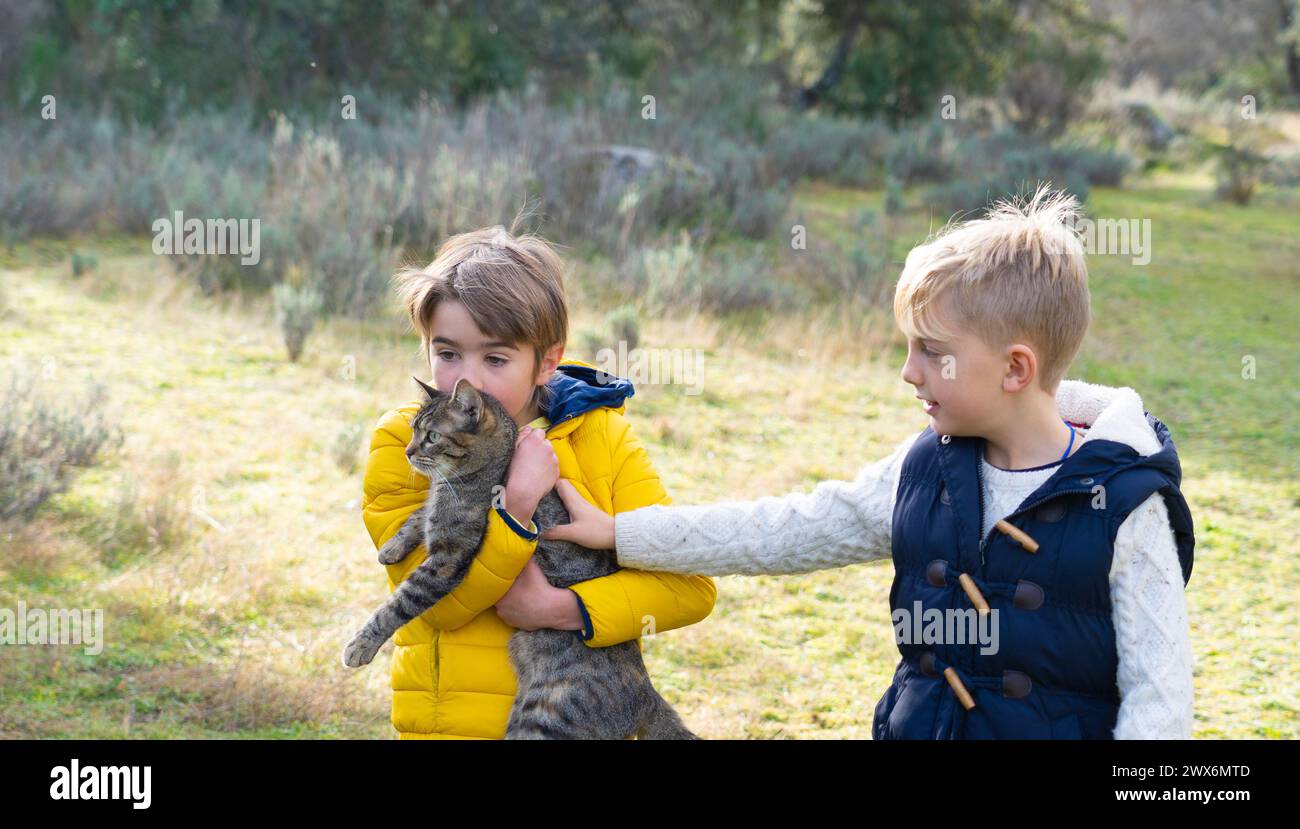 Bambini con il loro gatto in natura Foto Stock