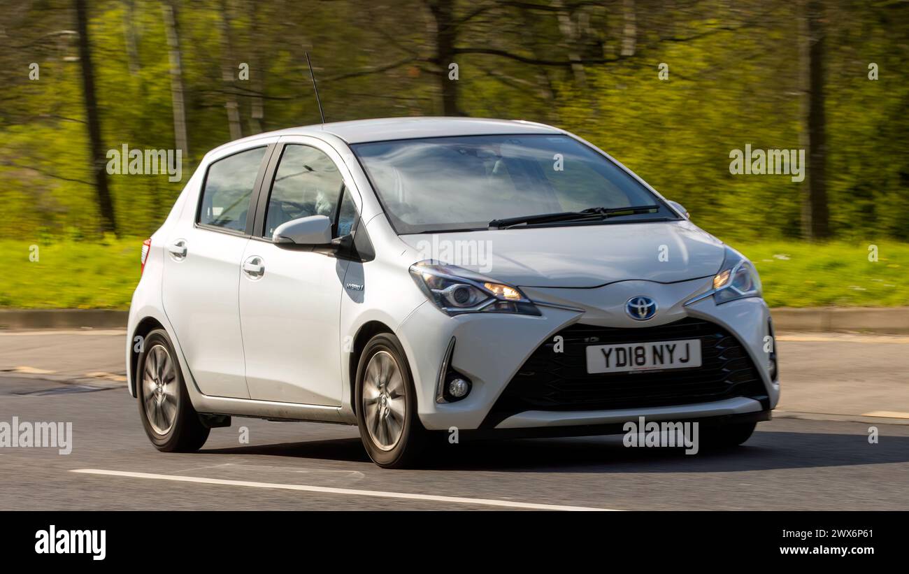 Milton Keynes, Regno Unito-26 marzo 2024: 2018 auto ibrida elettrica Toyota Yaris bianca che guida su una strada britannica Foto Stock