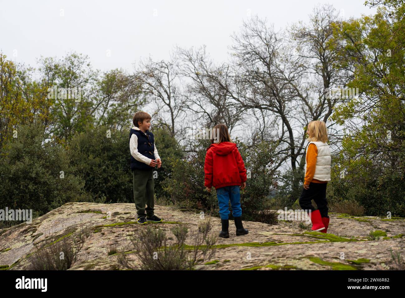 Tre bambini sul campo che giocano insieme Foto Stock