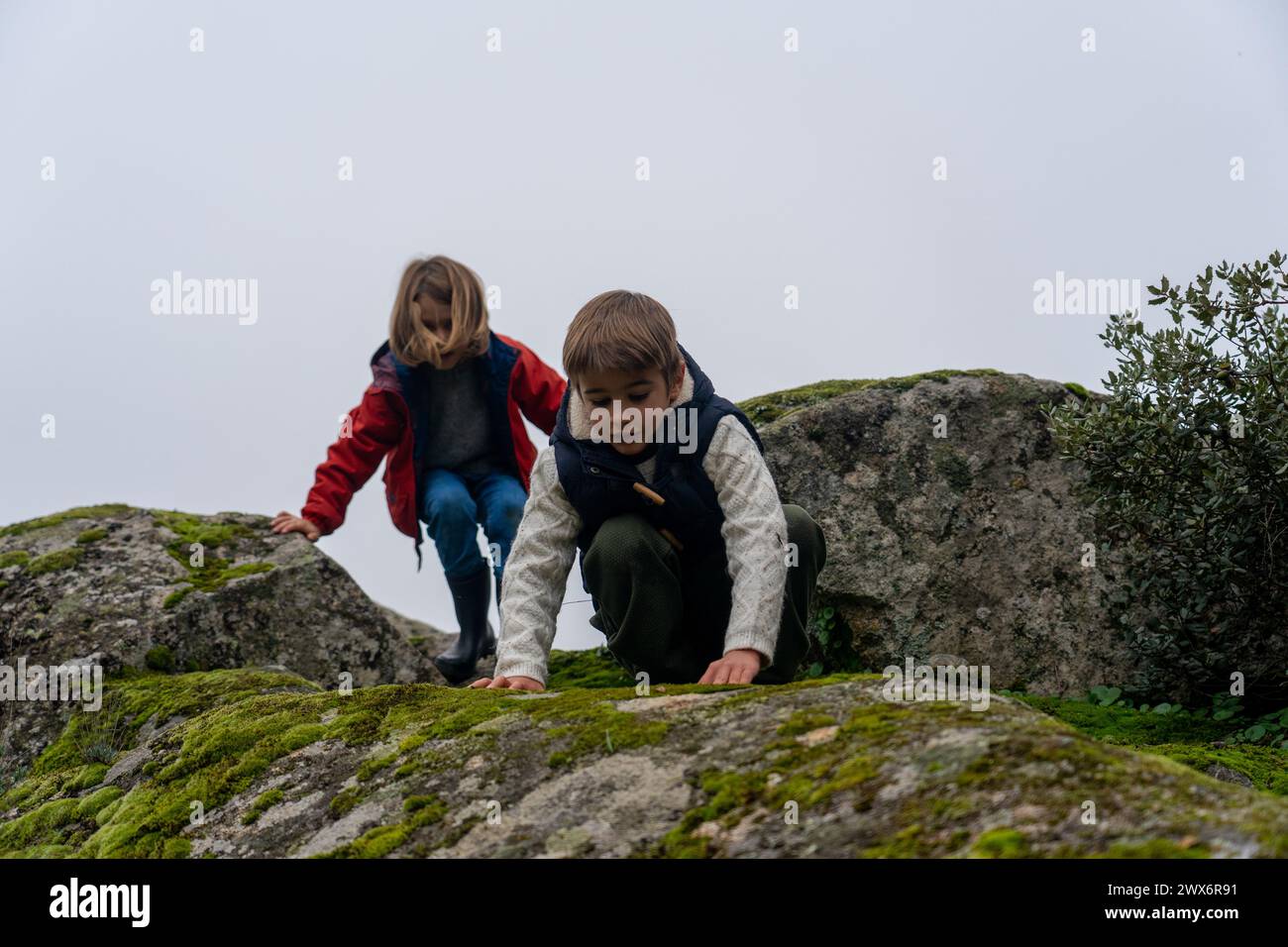 Bambini che giocano su rocce in natura Foto Stock