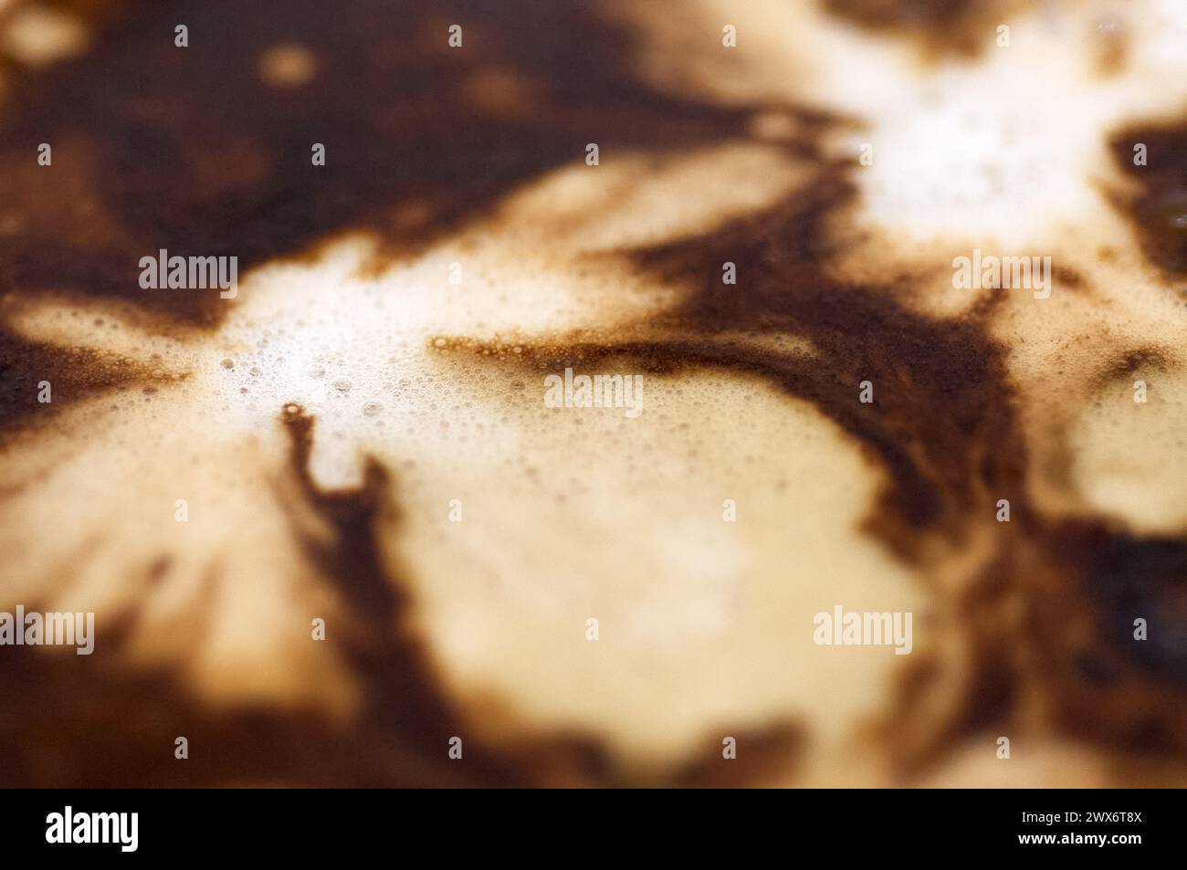 L'immagine mostra un caffè con un design astratto nella sua schiuma, creando un intrigante contrasto visivo che invita alla contemplazione. Foto Stock