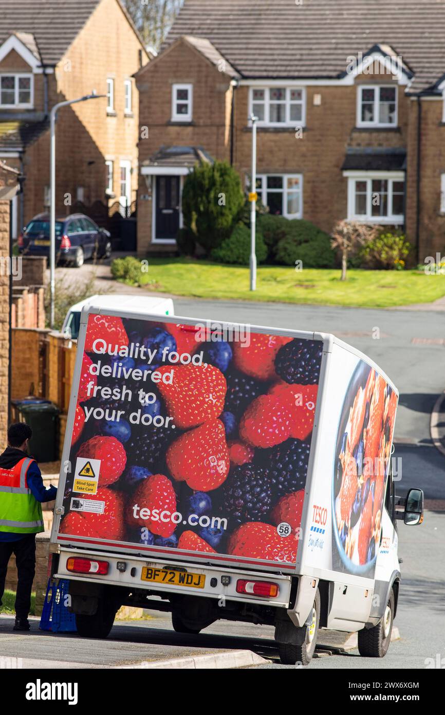 Un furgone Tesco consegna a domicilio consegna un ordine a una casa a Queensbury, West Yorkshire, Regno Unito. Nel giugno 2007, Tesco.com è diventata la prima società di consegna a domicilio nel Regno Unito a fornire ai clienti la possibilità di consegnare gli acquisti in scatole verdi senza borse, nel tentativo di ridurre la quantità di borse utilizzate come parte dell'impegno ecologico di Tesco. In cambio, i clienti che usufruiscono della borsa gratuita riceveranno punti green clubcard. Dopo aver provato un servizio di consegna completamente senza sacco, Tesco ha smesso di utilizzare sacchetti di plastica e carta per tutti gli ordini online consegnati a partire dal 19 agosto 2019. Foto Stock