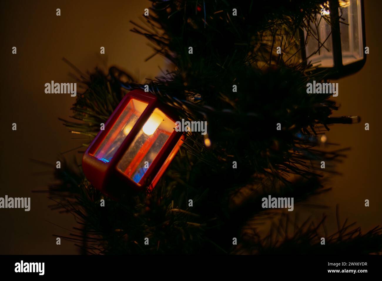 Le luminose lanterne a forma di lampione adornano l'albero di Natale, creando un'atmosfera festosa e lo spirito natalizio con un'illuminazione urbana decorativa. Foto Stock