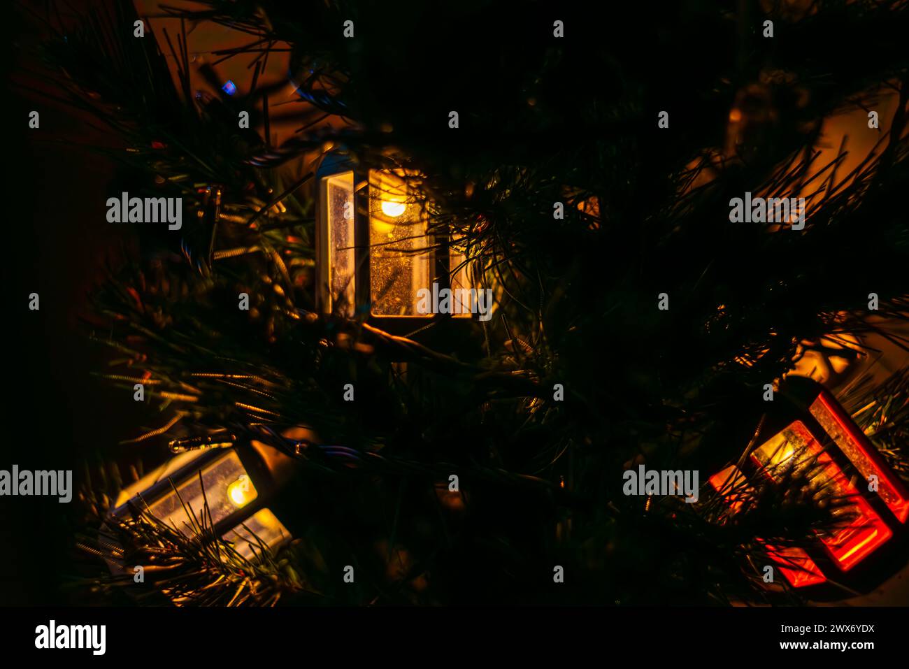 Le luminose lanterne a forma di lampione adornano l'albero di Natale, creando un'atmosfera festosa e lo spirito natalizio con un'illuminazione urbana decorativa. Foto Stock