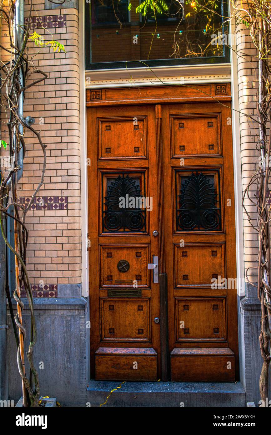 Una porta vintage abbellisce un muro in mattoni in una strada di Amsterdam, combinando fascino architettonico con un fascino urbano intramontabile. Foto Stock