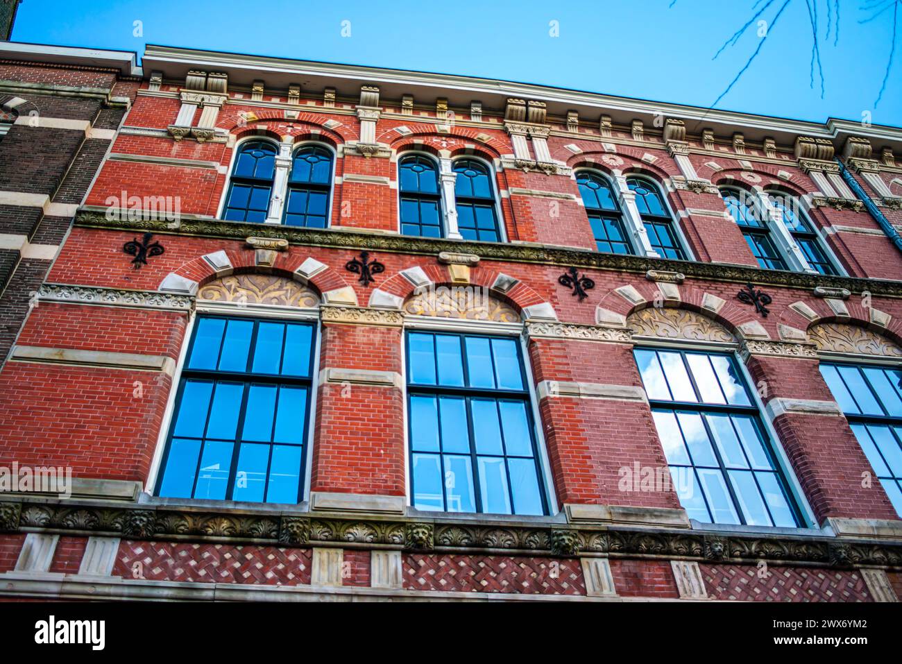 Esplora il fascino e il patrimonio architettonico di Amsterdam attraverso le sue strade vivaci, dove edifici iconici dipingono un pittoresco paesaggio urbano. Foto Stock
