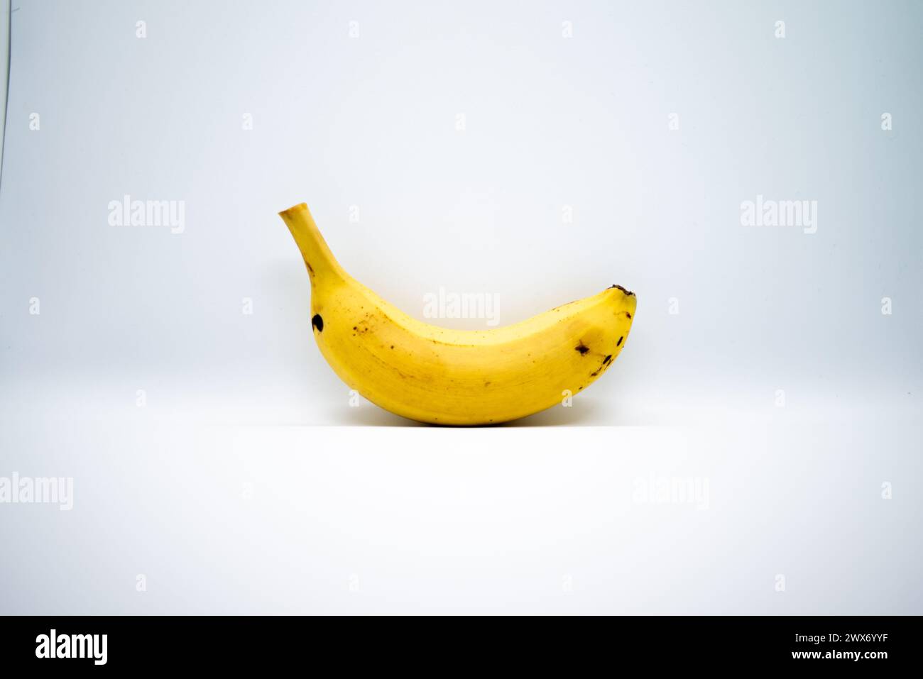 Una vivace banana gialla si distingue su un sfondo bianco puro, catturando l'essenza di un sano e nutriente spuntino tropicale. Foto Stock