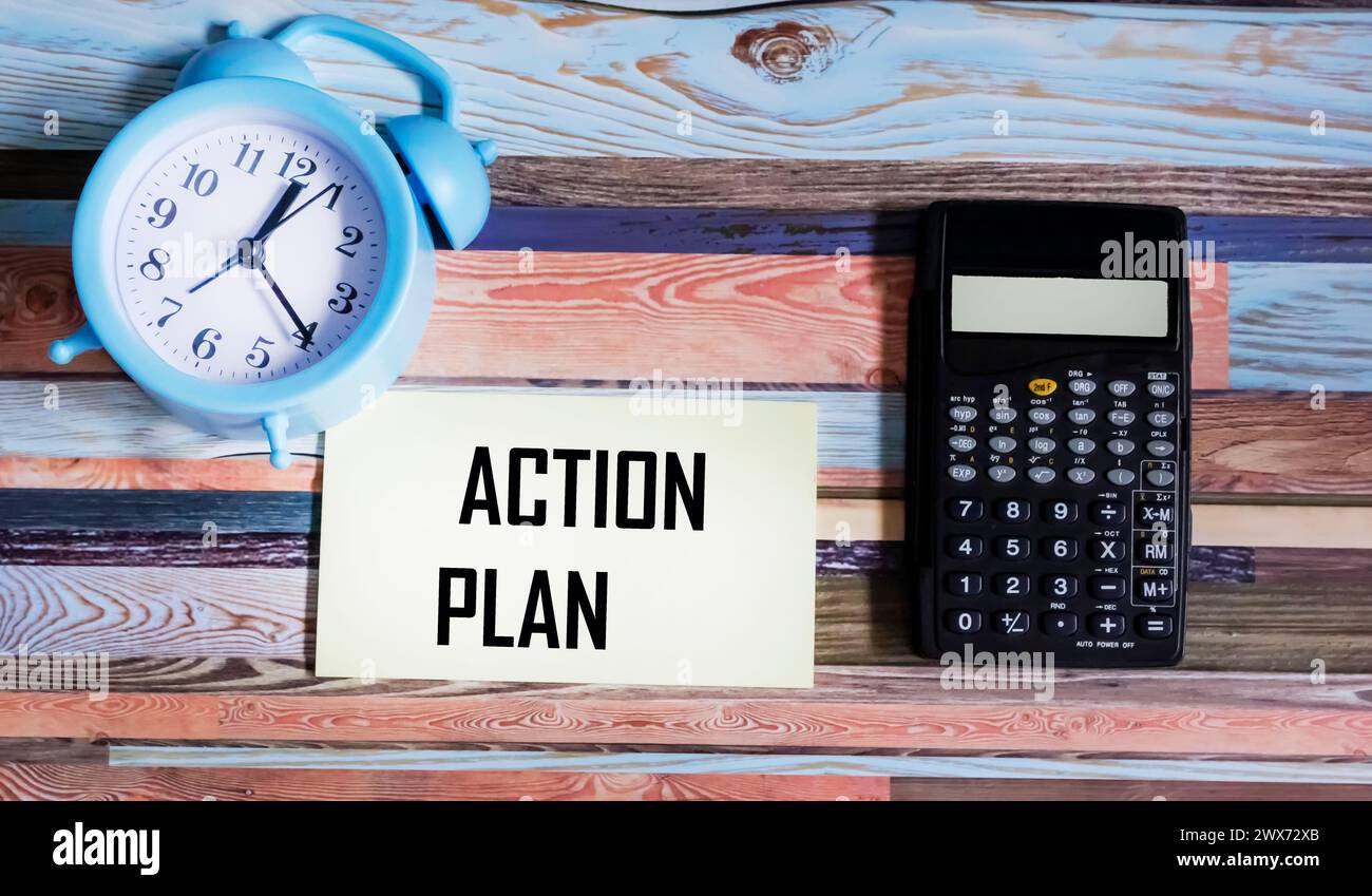testo del piano d'azione sul blocco note con cancelleria sul tavolo vintage Foto Stock