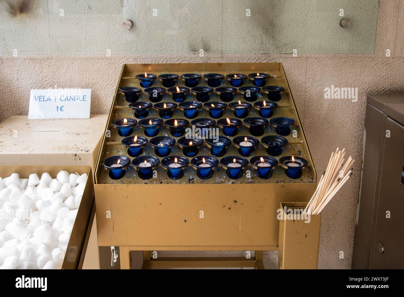 Stand di vendita nel santuario di Fátima, in Portogallo, con diverse candele bruciate in piccoli portabicchieri e 1 euro di prezzo scritto a mano Foto Stock