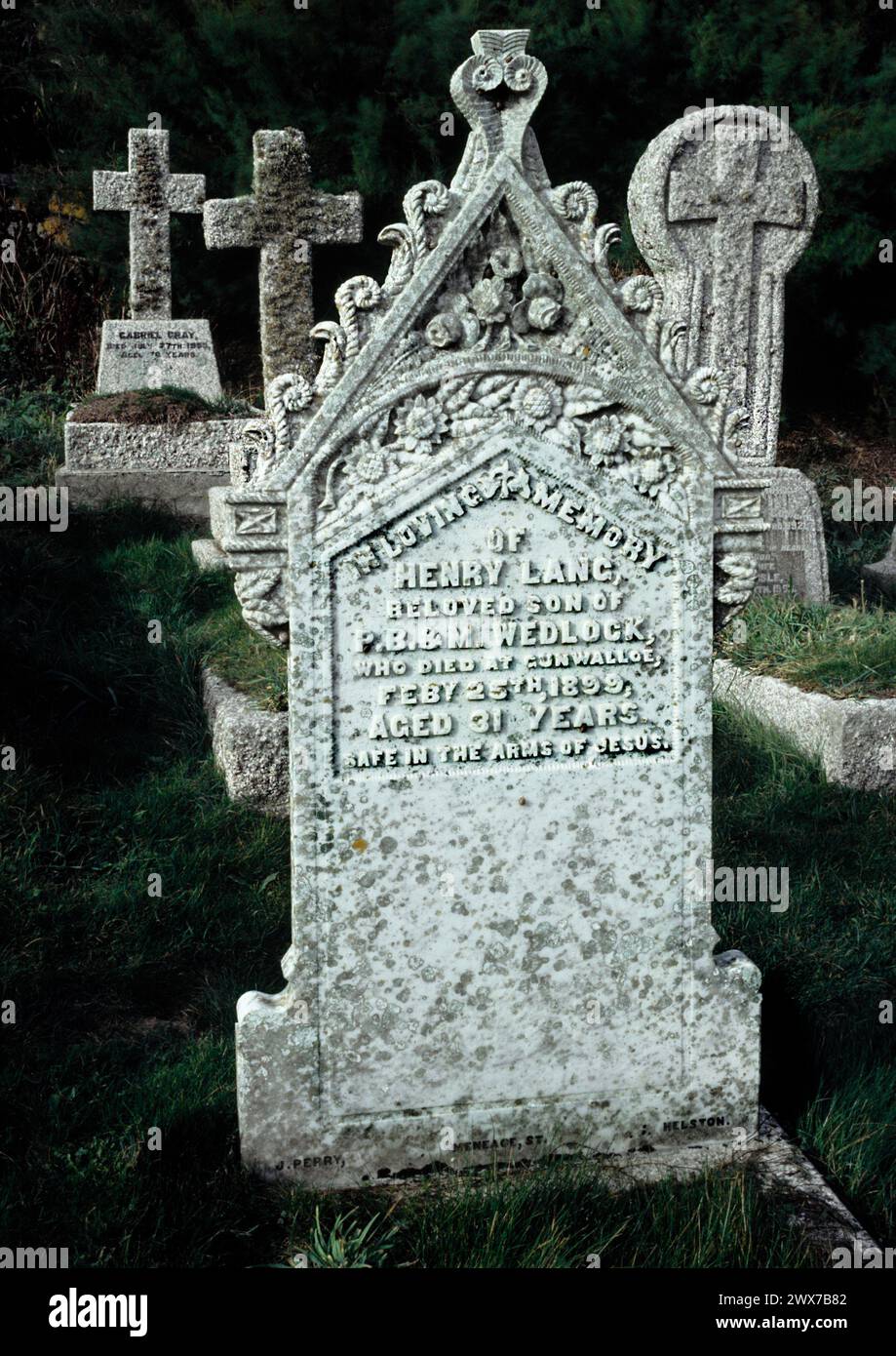 Chiesa di San Winwaloe, Gunwalloe, Church Cove, Cornovaglia. Lapide di granito in primo piano del XIX secolo ad Henry Lang 1899. Foto Stock