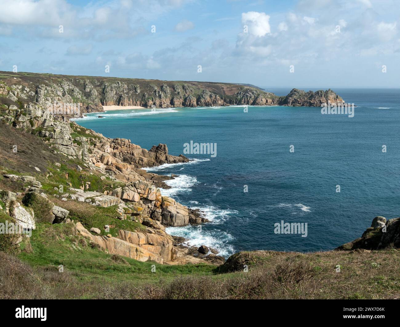 Costa rocciosa della Cornovaglia vicino a Porthcurno con spiaggia di Pedn Vounder e promontorio di Logan Rock in lontananza, Cornovaglia, Inghilterra, Regno Unito Foto Stock