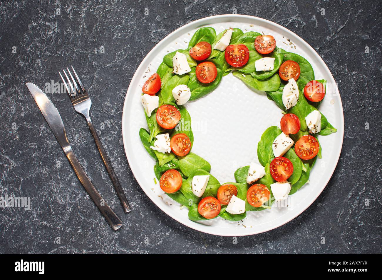 Insalata caprese italiana con pomodori, mozzarella, basilico, olio d'oliva su fondo in pietra. Vista dall'alto. Cucina italiana. Foto Stock