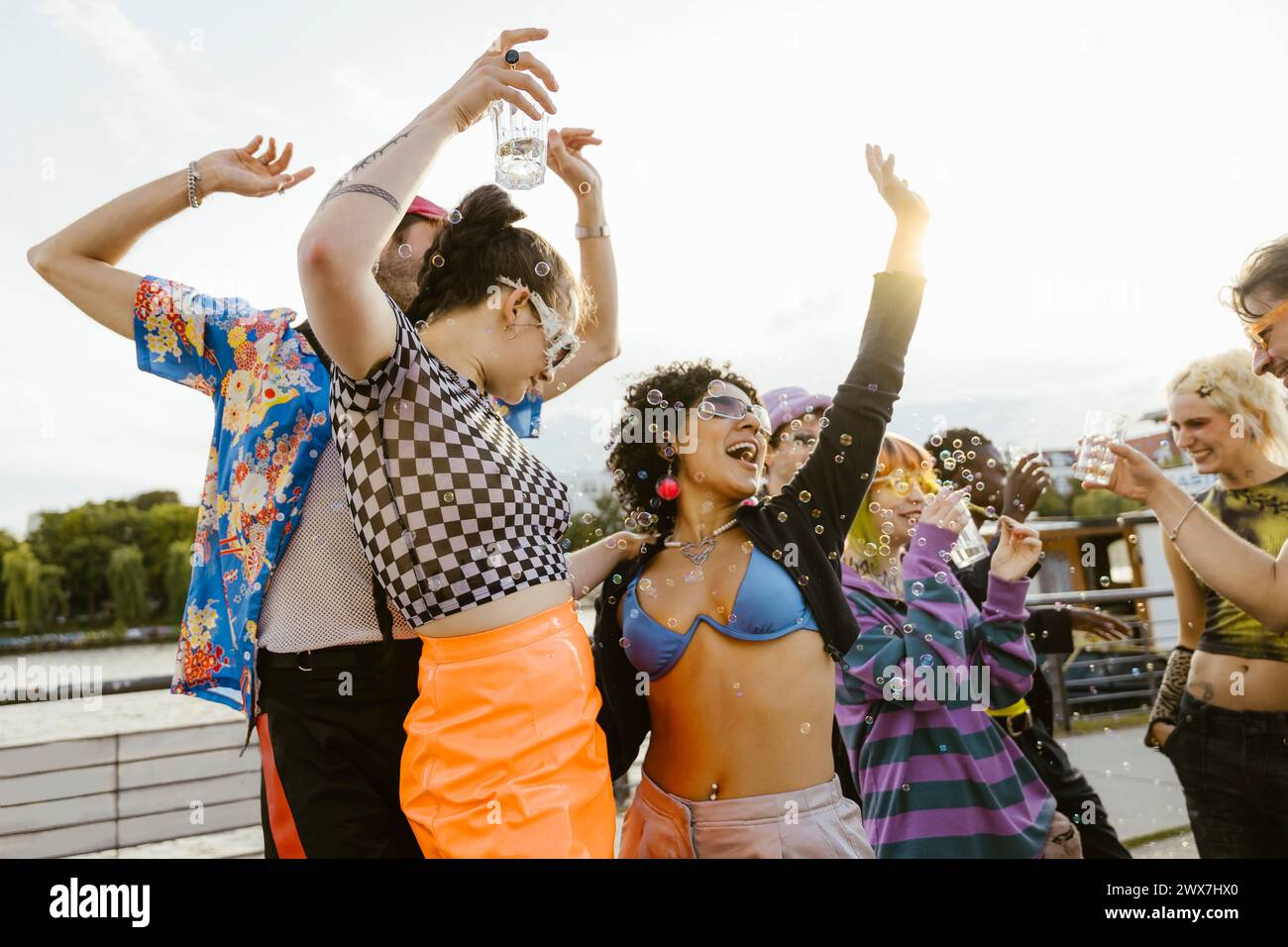 Amici non binari multirazziali spensierati che ballano tra loro in città Foto Stock