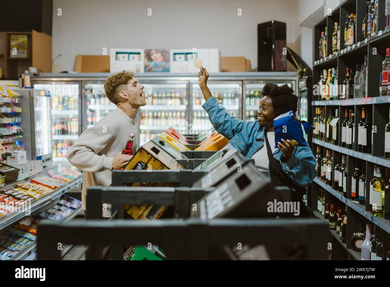 Coppia giocherellona che si diverte mentre fai shopping al supermercato Foto Stock