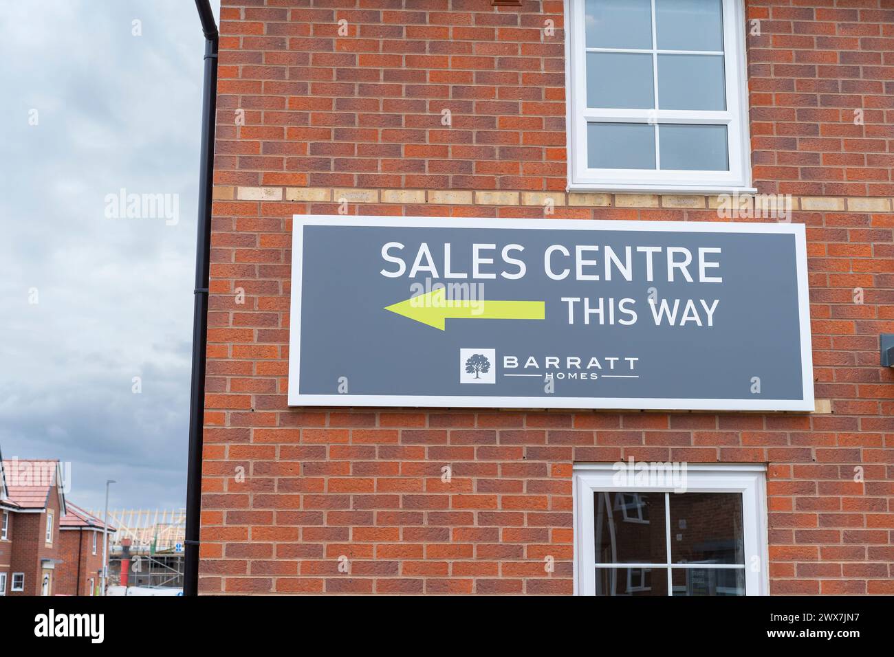 Barratt Homes Sales Centre firma fissata a una nuova costruzione di una casa finita pronta per la vendita sul nuovo sito di sviluppo immobiliare nelle Midlands, Regno Unito. Foto Stock