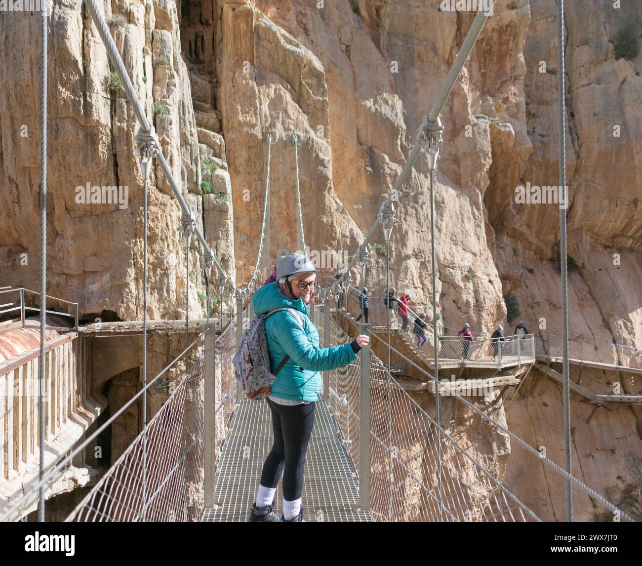 escursionista donna adulta che guarda indietro poco prima di attraversare un'altra piattaforma sospesa. Foto Stock
