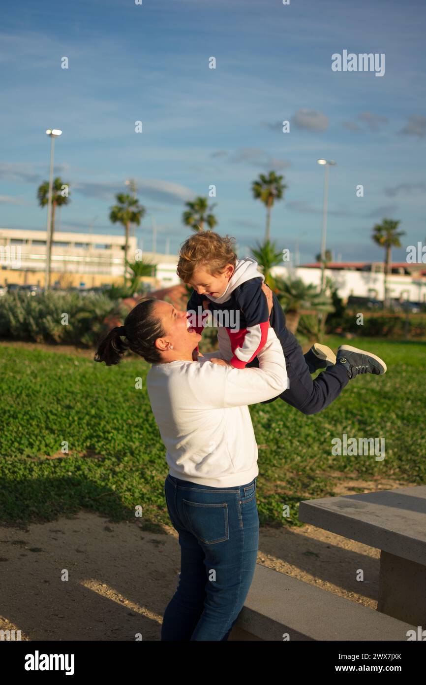 madre e figlio condividono i giochi nel parco, sono pieni di gioia Foto Stock