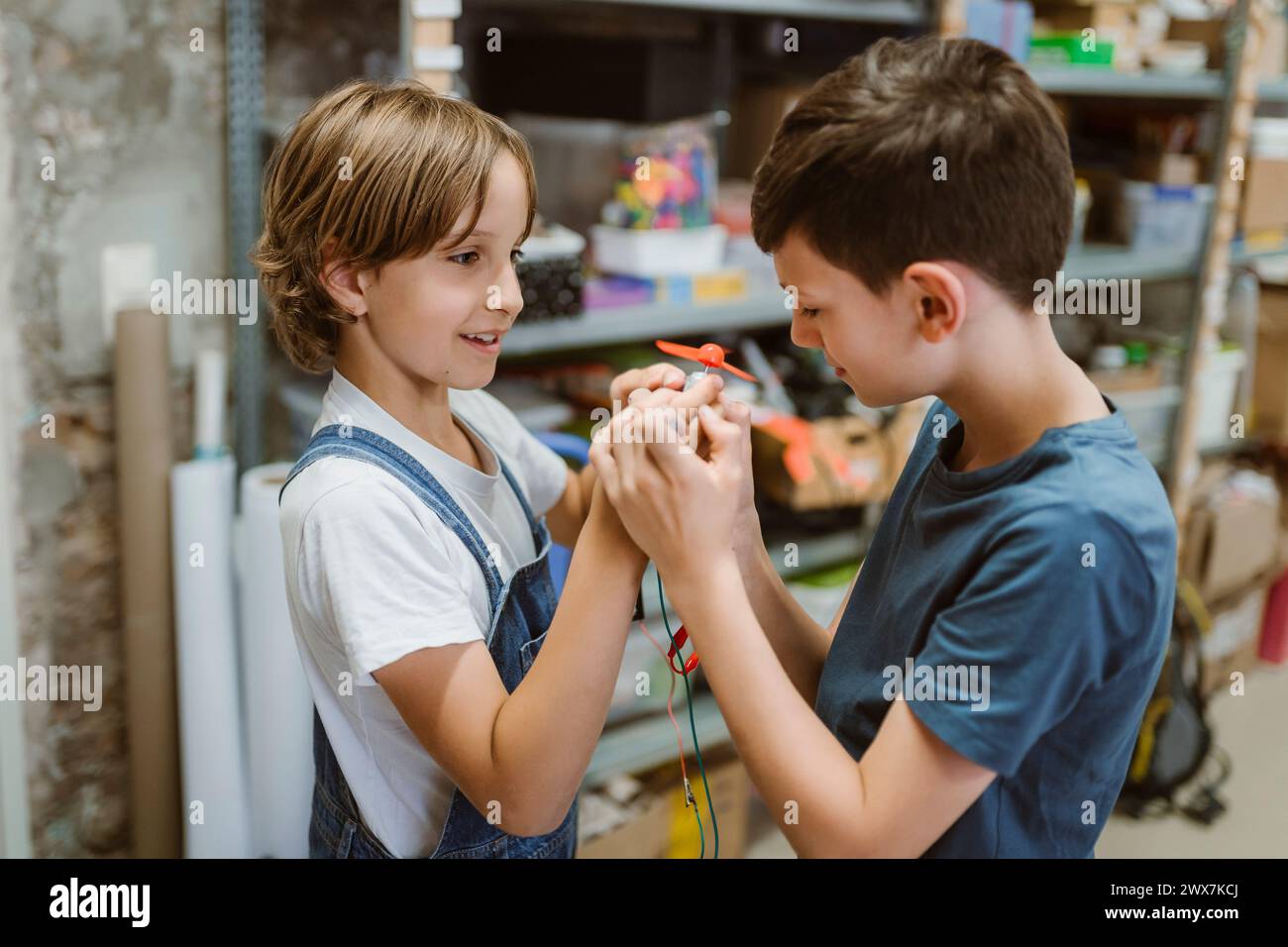 Studenti maschi e femmine curiosi che esaminano il motore elettrico in officina a scuola Foto Stock