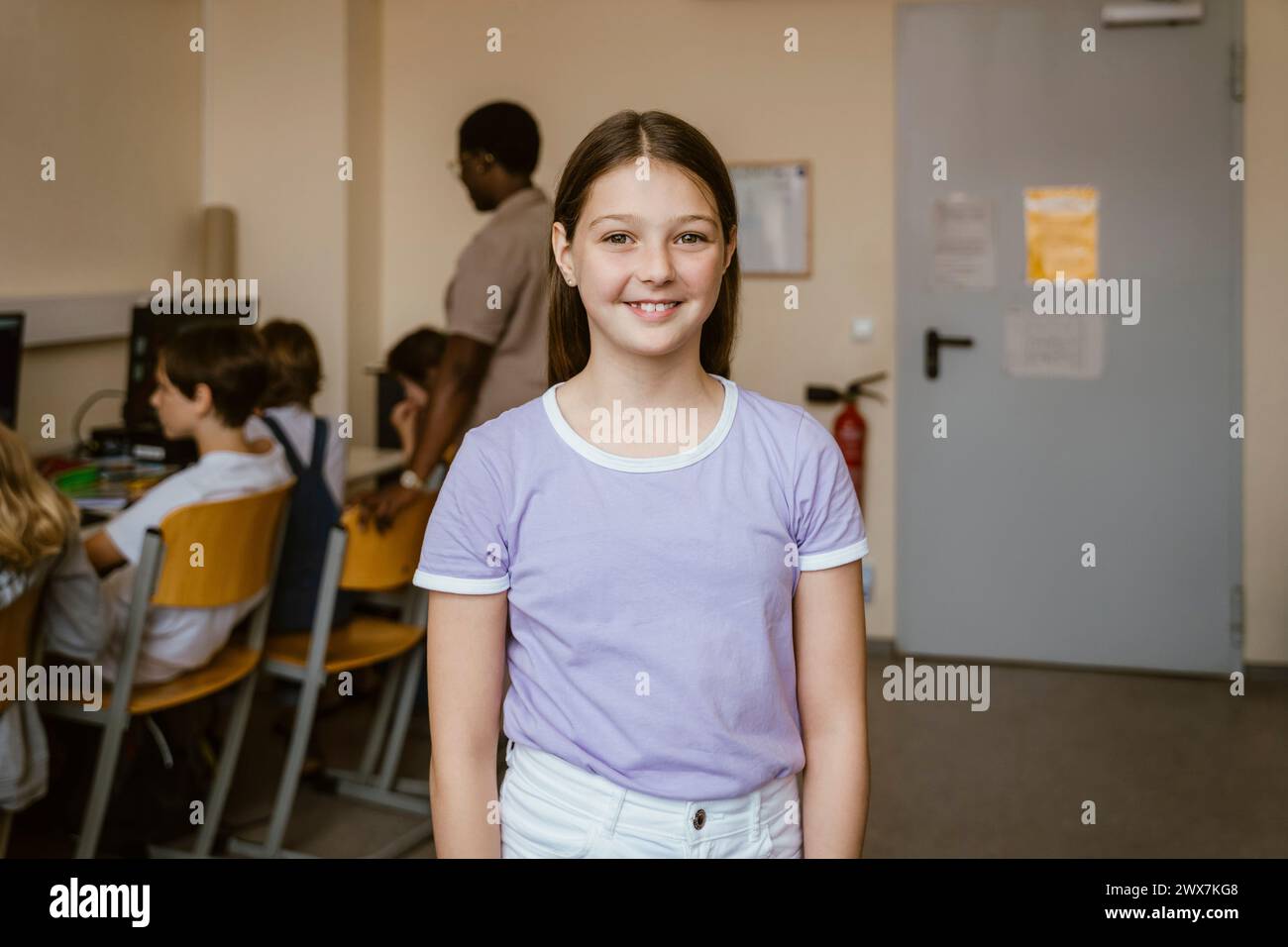 Ritratto di una ragazza sorridente in classe di computer a scuola Foto Stock