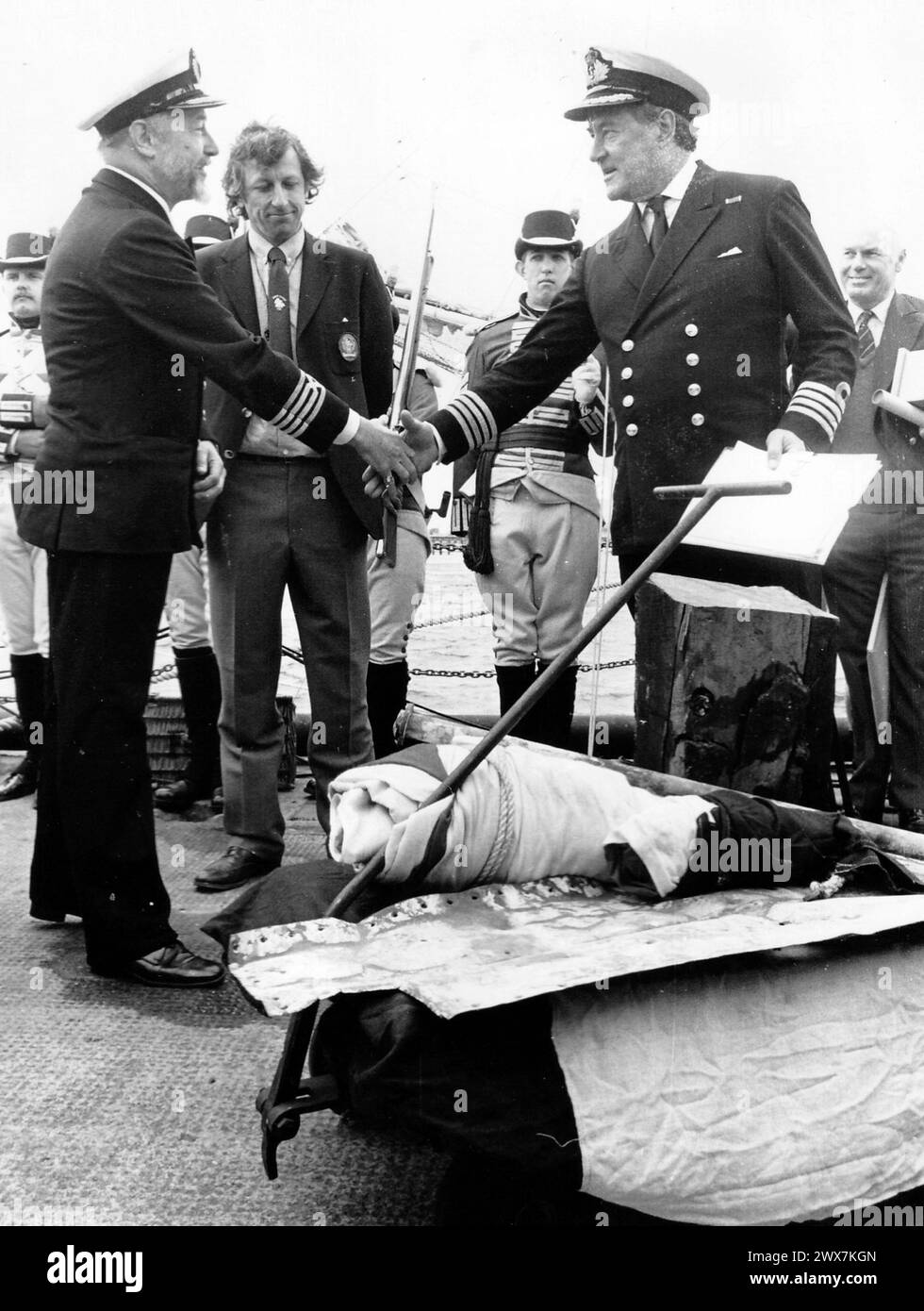 IL CAPOSTIPITE DEL QUEENS, IL CAPT CHRISTOPHER CHAMBERLAND, PRESENTA DEI RIFORNIMENTI PER SCHERZO AL CAPITANO AUSTRALIANO MIKE KITCHENSIDE MENTRE LA PRIMA FLOTTA BICENTENARIA SALPA DA PORTSMOUTH, 1988 PIC MIKE WALKER 1988 Foto Stock