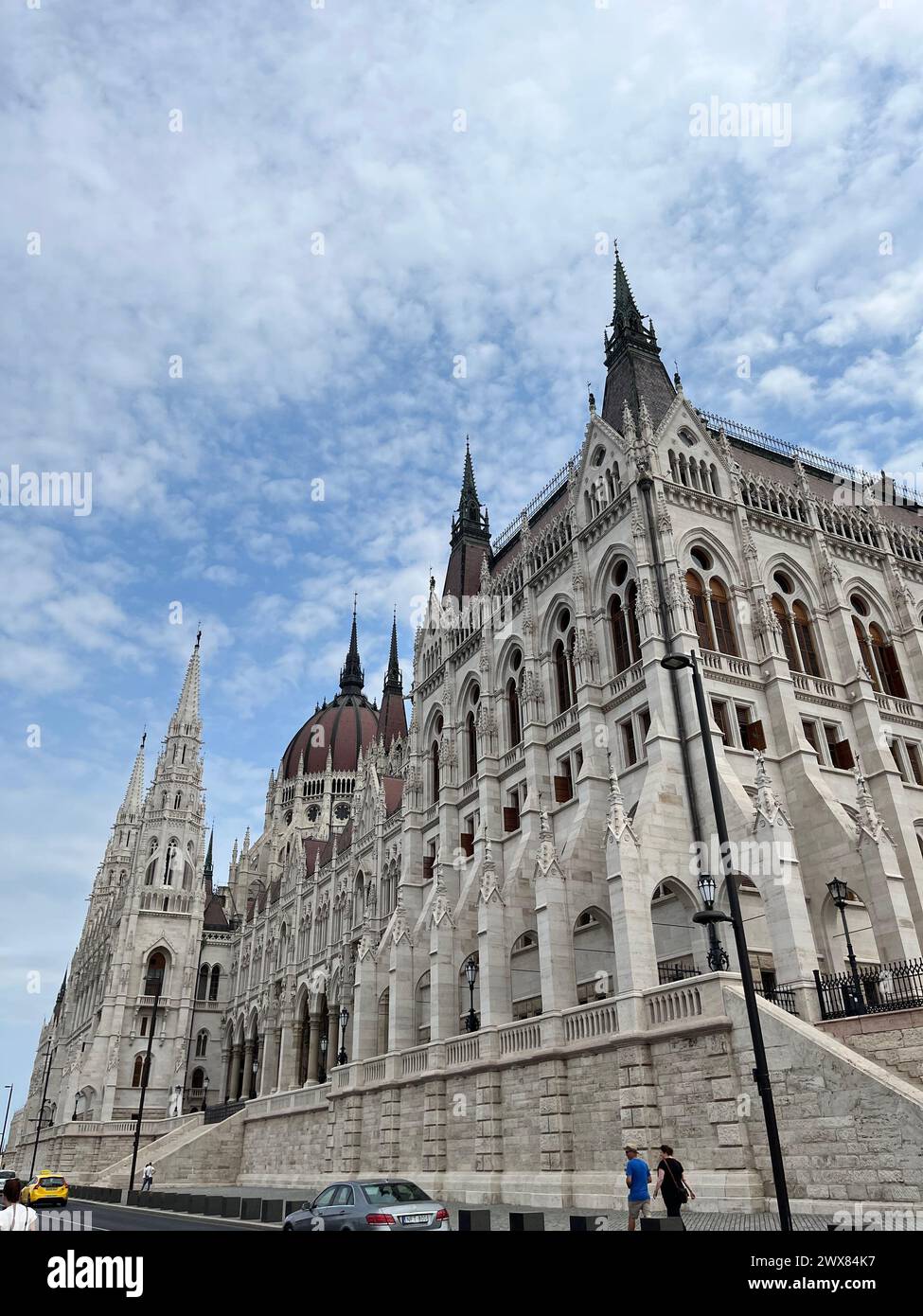 Un gruppo di individui su un marciapiede della città vicino a un grattacielo torreggiante Foto Stock