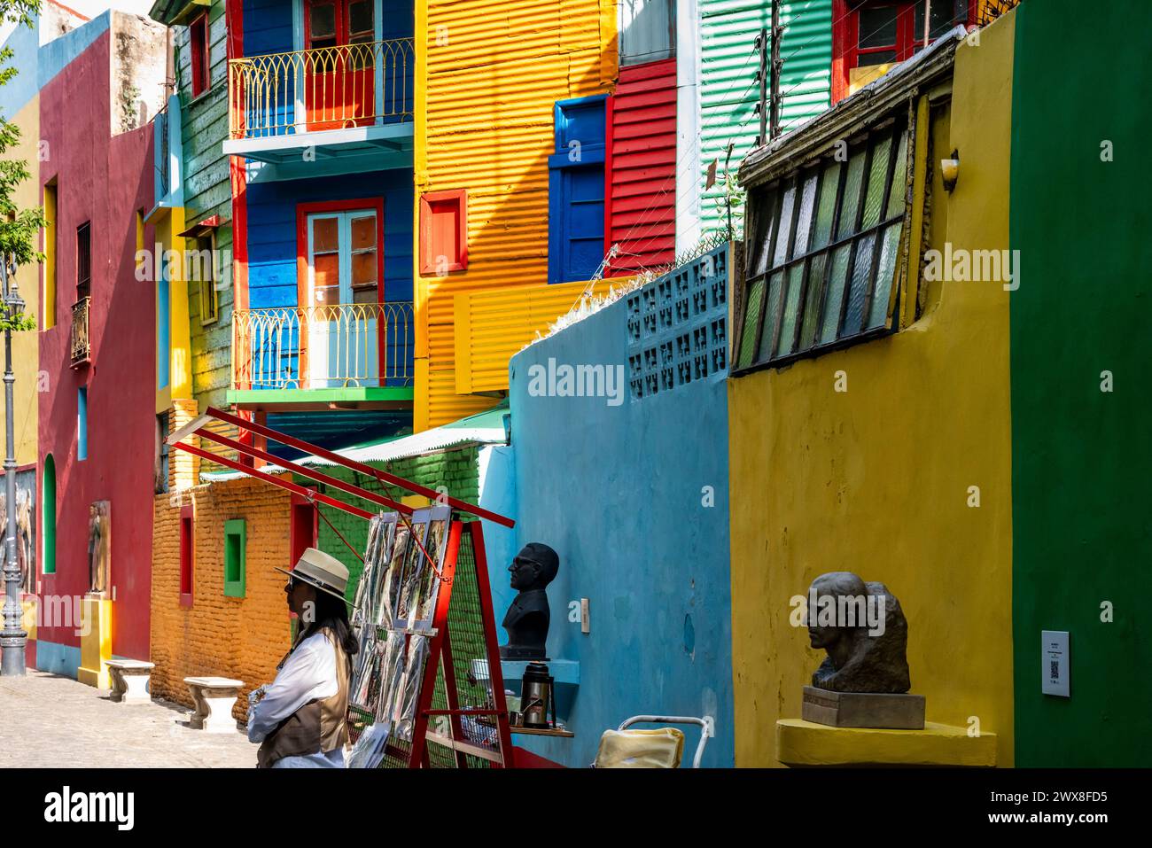 Una donna vende dipinti nel colorato quartiere la Boca di Buenos Aires, Argentina. Foto Stock